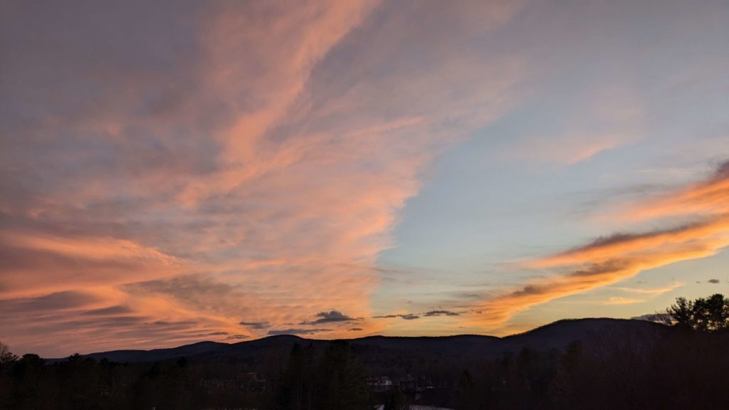 A picture of a silhouette of a mountain range contrasted against a vibrant sunset.